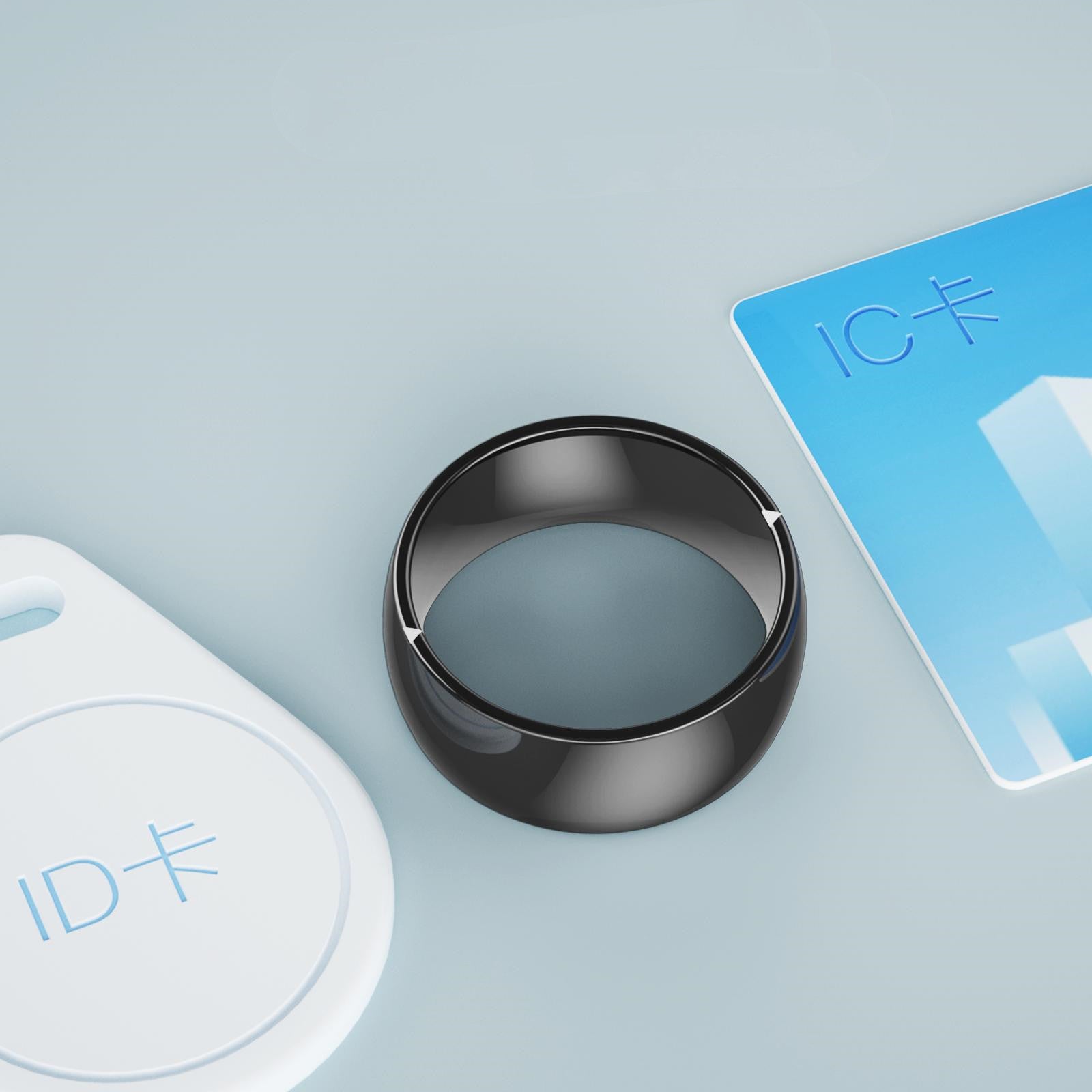 Black circular device with a blue card and white card on a light gray background