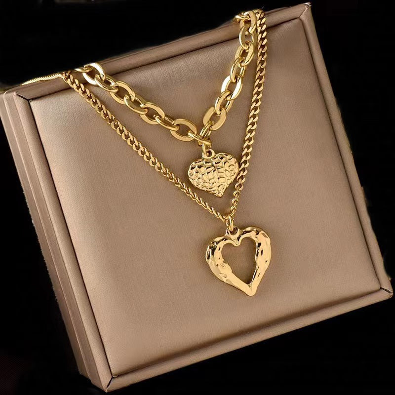 Gold heart-shaped necklace on a beige jewelry box
