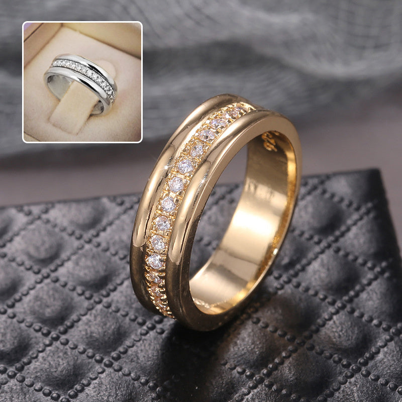 Gold ring with diamond accents on a textured surface