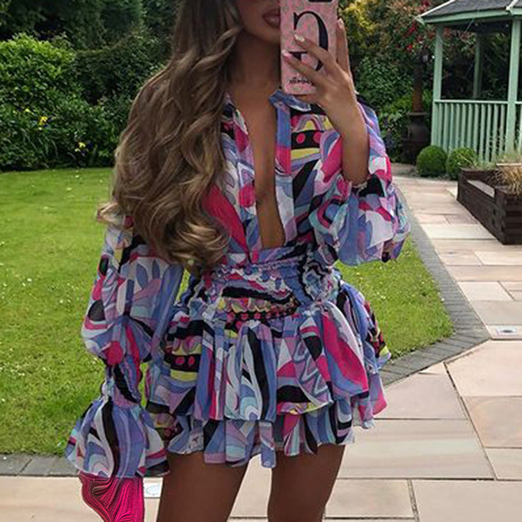 A woman wearing a multicolored floral and geometric patterned V-neck dress with short sleeves and a mini skirt length.